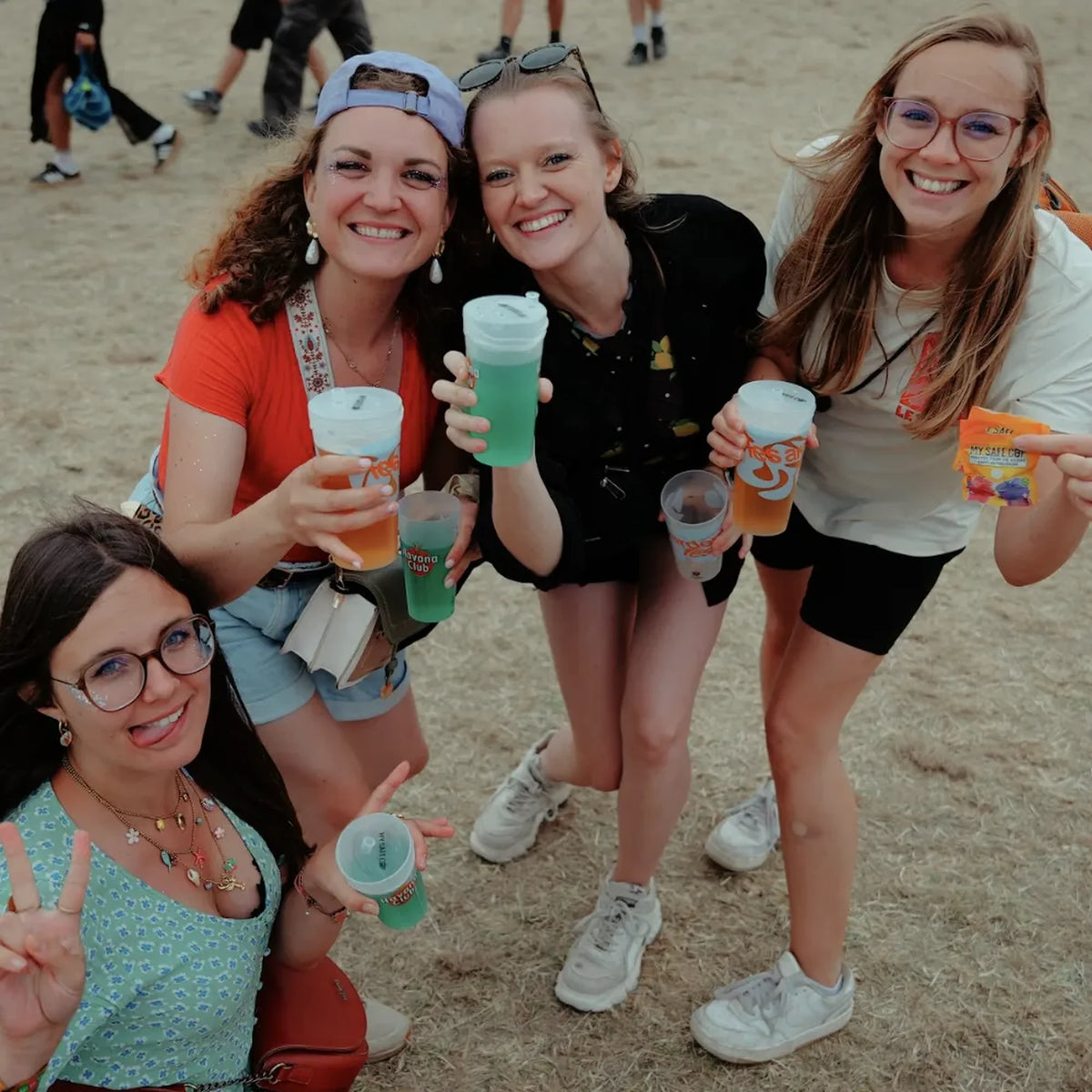 Quatre festivalières trinquant avec des verres équipés de protections My Safe Cup